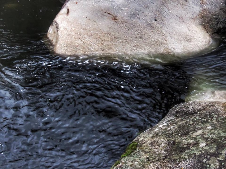 El río Jerte, negro, tras el incendio en Los Infiernos