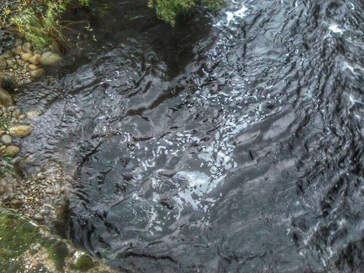 El río Jerte, negro, tras el incendio en Los Infiernos