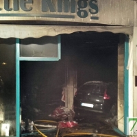 Un coche se empotra contra una tienda y sale ardiendo