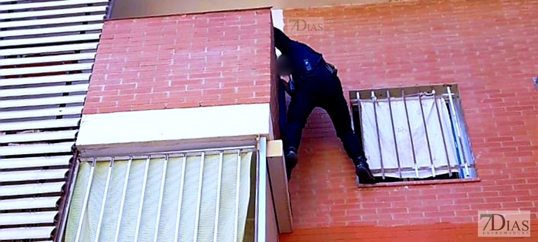 Un policía nacional escala por la fachada de un edificio para rescatar a una niña