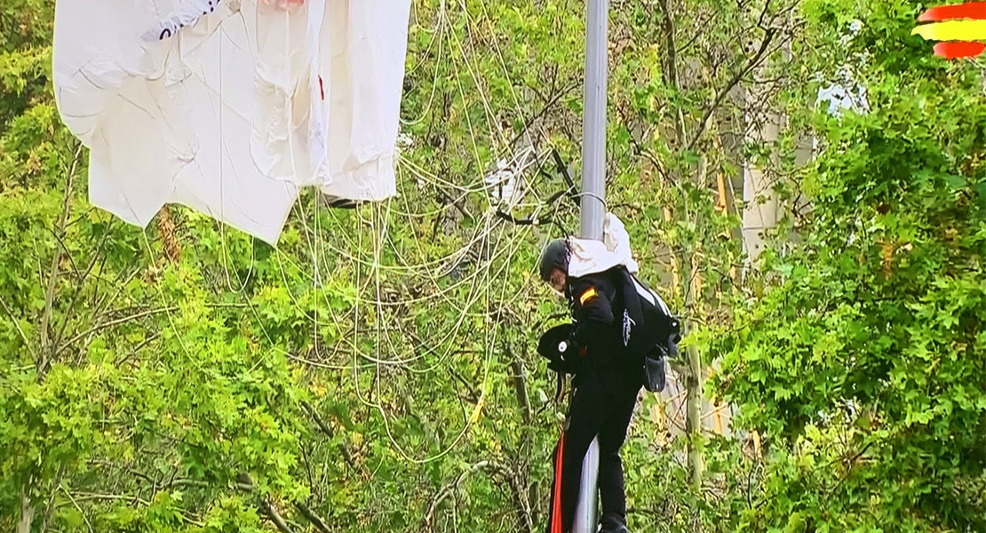El paracaidista que llevaba la Bandera nacional se engancha con una farola antes de aterrizar