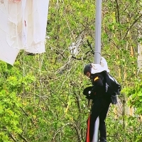 El paracaidista que llevaba la Bandera nacional se engancha con una farola antes de aterrizar