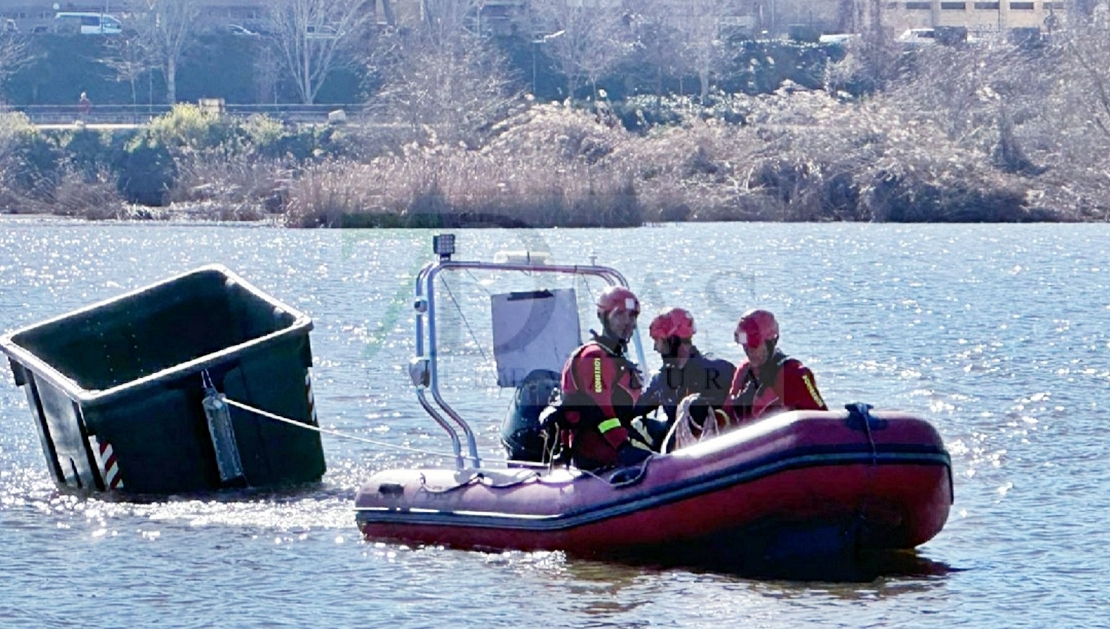 Los bomberos extraen un contenedor de basura municipal tras varios días en el río