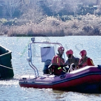 Los bomberos extraen un contenedor de basura municipal tras varios días en el río