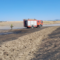 Los bomberos evitan que un incendio forestal calcine una cosechadora en Malpartida de Cáceres