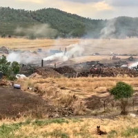 Bomberos de cuatro parques y vecinos combaten un incendio en unas carboneras en Extremadura